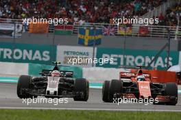 Kevin Magnussen (DEN) Haas VF-17 and Fernando Alonso (ESP) McLaren MCL32. 01.10.2017. Formula 1 World Championship, Rd 15, Malaysian Grand Prix, Sepang, Malaysia, Sunday.