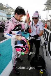 Sergio Perez (MEX) Sahara Force India F1 on the grid with Xavi Martos (ESP) Sahara Force India F1 Team Physio. 26.11.2017. Formula 1 World Championship, Rd 20, Abu Dhabi Grand Prix, Yas Marina Circuit, Abu Dhabi, Race Day.