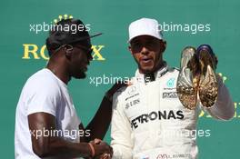 Usain Bolt (JAM) Athlete gifts Lewis Hamilton (GBR) Mercedes AMG F1 with a pair of trainers. 22.10.2017. Formula 1 World Championship, Rd 17, United States Grand Prix, Austin, Texas, USA, Race Day.