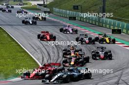 Valtteri Bottas (FIN) Mercedes AMG F1 W09 and Kimi Raikkonen (FIN) Ferrari SF71H battle for position at the start of the race. 01.07.2018. Formula 1 World Championship, Rd 9, Austrian Grand Prix, Spielberg, Austria, Race Day.
