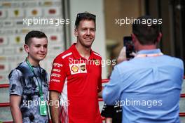 Sebastian Vettel (GER) Ferrari with young fans. 05.04.2018. Formula 1 World Championship, Rd 2, Bahrain Grand Prix, Sakhir, Bahrain, Preparation Day.