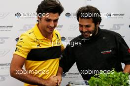(L to R): Carlos Sainz Jr (ESP) Renault Sport F1 Team with Omar Allibhoy (ESP) Celebrity Chef - cooking with Estrella Galicia. 05.07.2018. Formula 1 World Championship, Rd 10, British Grand Prix, Silverstone, England, Preparation Day.