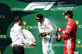 (L to R): Race winner Lewis Hamilton (GBR) Mercedes AMG F1 celebrates with the champagne on the podium with second placed Sebastian Vettel (GER) Ferrari. 29.07.2018. Formula 1 World Championship, Rd 12, Hungarian Grand Prix, Budapest, Hungary, Race Day.