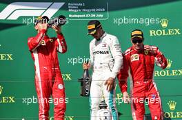 (L to R): Sebastian Vettel (GER) Ferrari celebrates with the champagne his second position on the podium with race winner Lewis Hamilton (GBR) Mercedes AMG F1 and third placed Kimi Raikkonen (FIN) Ferrari. 29.07.2018. Formula 1 World Championship, Rd 12, Hungarian Grand Prix, Budapest, Hungary, Race Day.