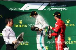 (L to R): Race winner Lewis Hamilton (GBR) Mercedes AMG F1 celebrates with the champagne on the podium with second placed Sebastian Vettel (GER) Ferrari. 29.07.2018. Formula 1 World Championship, Rd 12, Hungarian Grand Prix, Budapest, Hungary, Race Day.
