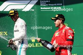 (L to R): Race winner Lewis Hamilton (GBR) Mercedes AMG F1 celebrates with the champagne on the podium with second placed Sebastian Vettel (GER) Ferrari. 29.07.2018. Formula 1 World Championship, Rd 12, Hungarian Grand Prix, Budapest, Hungary, Race Day.