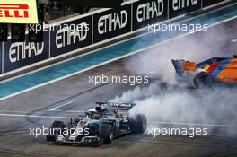 Race winner Lewis Hamilton (GBR) Mercedes AMG F1 W09 and Fernando Alonso (ESP) McLaren MCL33 perform doughnuts at the end of the race. 25.11.2018. Formula 1 World Championship, Rd 21, Abu Dhabi Grand Prix, Yas Marina Circuit, Abu Dhabi, Race Day.