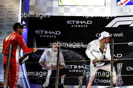 (L to R): Sebastian Vettel (GER) Ferrari celebrates his second position on the podium with Bradley Lord (GBR) Mercedes AMG F1 Communications Manager and race winner Lewis Hamilton (GBR) Mercedes AMG F1. 25.11.2018. Formula 1 World Championship, Rd 21, Abu Dhabi Grand Prix, Yas Marina Circuit, Abu Dhabi, Race Day.