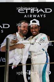 Race winner Lewis Hamilton (GBR) Mercedes AMG F1 celebrates on the podium with Bradley Lord (GBR) Mercedes AMG F1 Communications Manager. 25.11.2018. Formula 1 World Championship, Rd 21, Abu Dhabi Grand Prix, Yas Marina Circuit, Abu Dhabi, Race Day.