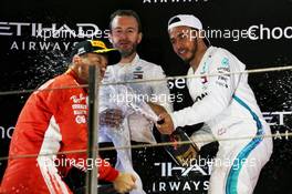 Race winner Lewis Hamilton (GBR) Mercedes AMG F1 celebrates on the podium with Bradley Lord (GBR) Mercedes AMG F1 Communications Manager and Sebastian Vettel (GER) Ferrari. 25.11.2018. Formula 1 World Championship, Rd 21, Abu Dhabi Grand Prix, Yas Marina Circuit, Abu Dhabi, Race Day.