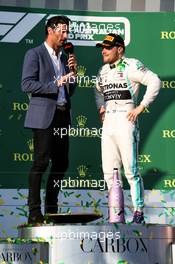 Race winner Valtteri Bottas (FIN) Mercedes AMG F1 on the podium with Mark Webber (AUS) Channel 4 Presenter. 17.03.2019. Formula 1 World Championship, Rd 1, Australian Grand Prix, Albert Park, Melbourne, Australia, Race Day.