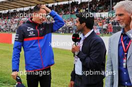 (L to R): Alexander Albon (THA) Scuderia Toro Rosso with Karun Chandhok (IND) Sky Sports F1 Pitlane Reporter and Damon Hill (GBR) Sky Sports Presenter on the drivers parade. 14.07.2019. Formula 1 World Championship, Rd 10, British Grand Prix, Silverstone, England, Race Day.