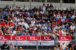 Charles Leclerc (MON) Ferrari banners and fans in the grandstand.