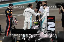 Lewis Hamilton (GBR) Mercedes AMG F1 celebrates his pole position in qualifying parc ferme with Max Verstappen (NLD) Red Bull Racing (Left) and team mate Valtteri Bottas (FIN) Mercedes AMG F1 (Right). 30.11.2019. Formula 1 World Championship, Rd 21, Abu Dhabi Grand Prix, Yas Marina Circuit, Abu Dhabi, Qualifying Day.