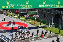 Some of the drivers take a knee on the grid, all wearing 'End Racism' T-shirts and Lewis Hamilton (GBR) Mercedes AMG F1 a 'Black Lives Matter' T-Shirt. 05.07.2020. Formula 1 World Championship, Rd 1, Austrian Grand Prix, Spielberg, Austria, Race Day.