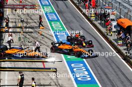Carlos Sainz Jr (ESP) McLaren MCL35, Lando Norris (GBR) McLaren MCL35 and Max Verstappen (NLD) Red Bull Racing RB16 in the pits. 04.07.2020. Formula 1 World Championship, Rd 1, Austrian Grand Prix, Spielberg, Austria, Qualifying Day.