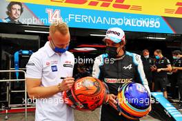 (L to R): Nikita Mazepin (RUS) Haas F1 Team and Fernando Alonso (ESP) Alpine F1 Team - helmet swap. 17.06.2021. Formula 1 World Championship, Rd 7, French Grand Prix, Paul Ricard, France, Preparation Day.