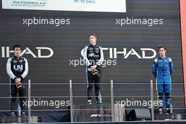 The podium (L to R): Guanyu Zhou (CHN) Uni-Virtuosi Racing, second; Oscar Piastri (AUS) PREMA Racing, race winner; Felipe Drugovich (BRA) Uni-Virtuosi Racing, third. 12.12.2021. Formula 2 Championship, Rd 8, Yas Marina Circuit, Abu Dhabi, UAE, Feature Race, Sunday.