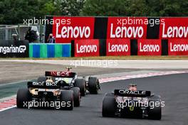 (L to R): Lando Norris (GBR) McLaren MCL36 and Max Verstappen (NLD) Red Bull Racing RB18 battle for position. 31.07.2022. Formula 1 World Championship, Rd 13, Hungarian Grand Prix, Budapest, Hungary, Race Day.