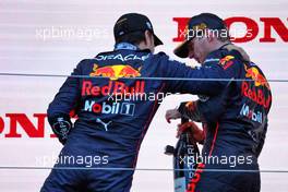 (L to R): Sergio Perez (MEX) Red Bull Racing celebrates with race winner Max Verstappen (NLD) Red Bull Racing on the podium. 09.10.2022. Formula 1 World Championship, Rd 18, Japanese Grand Prix, Suzuka, Japan, Race Day.