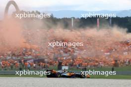 Lando Norris (GBR) McLaren MCL60 passes fans in the grandstand with flares being set off. 30.06.2023. Formula 1 World Championship, Rd 10, Austrian Grand Prix, Spielberg, Austria, Qualifying Day.