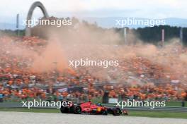 Carlos Sainz Jr (ESP) Ferrari SF-23 passes fans in the grandstand with flares being set off. 30.06.2023. Formula 1 World Championship, Rd 10, Austrian Grand Prix, Spielberg, Austria, Qualifying Day.