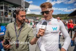 Logan Sargeant (USA) Williams Racing with Chris Medland (GBR) Journalist on the grid. 02.07.2023. Formula 1 World Championship, Rd 10, Austrian Grand Prix, Spielberg, Austria, Race Day.