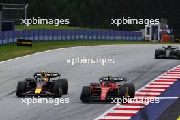 (L to R): Sergio Perez (MEX) Red Bull Racing RB19 and Carlos Sainz Jr (ESP) Ferrari SF-23 battle for position. 02.07.2023. Formula 1 World Championship, Rd 10, Austrian Grand Prix, Spielberg, Austria, Race Day.