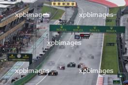 (L to R): Sergio Perez (MEX) Red Bull Racing RB19 and team mate Max Verstappen (NLD) Red Bull Racing RB19 battle for the lead at the start of the race. 01.07.2023. Formula 1 World Championship, Rd 10, Austrian Grand Prix, Spielberg, Austria, Sprint Day.