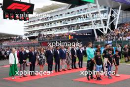 (L to R): George Russell (GBR) Mercedes AMG F1; Lewis Hamilton (GBR) Mercedes AMG F1; and Lando Norris (GBR) McLaren as the grid observes the national anthem. 09.07.2023. Formula 1 World Championship, Rd 11, British Grand Prix, Silverstone, England, Race Day.