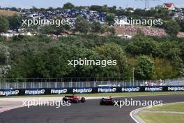 Carlos Sainz Jr (ESP) Ferrari SF-23 and Sergio Perez (MEX) Red Bull Racing RB19 battle for position. 23.07.2023. Formula 1 World Championship, Rd 12, Hungarian Grand Prix, Budapest, Hungary, Race Day.