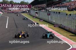 Sergio Perez (MEX) Red Bull Racing RB19 and Fernando Alonso (ESP) Aston Martin F1 Team AMR23 battle for position. 23.07.2023. Formula 1 World Championship, Rd 12, Hungarian Grand Prix, Budapest, Hungary, Race Day.