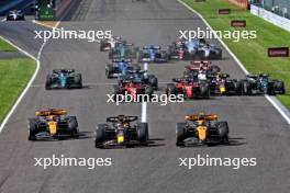 (L to R): Oscar Piastri (AUS) McLaren MCL60; Max Verstappen (NLD) Red Bull Racing RB19; and Lando Norris (GBR) McLaren MCL60 lead at the start of the race as Lewis Hamilton (GBR) Mercedes AMG F1 W14 runs wide after contact with Sergio Perez (MEX) Red Bull Racing RB19 and Alexander Albon (THA) Williams Racing FW45 is airborne after contact with Valtteri Bottas (FIN) Alfa Romeo F1 Team C43. 24.09.2023. Formula 1 World Championship, Rd 17, Japanese Grand Prix, Suzuka, Japan, Race Day.