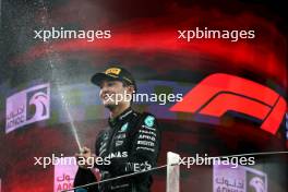 George Russell (GBR) Mercedes AMG F1 celebrates his third position on the podium. 26.11.2023. Formula 1 World Championship, Rd 23, Abu Dhabi Grand Prix, Yas Marina Circuit, Abu Dhabi, Race Day.