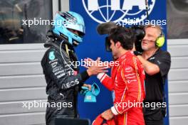 (L to R): Race winner George Russell (GBR) Mercedes AMG F1 celebrates with third placed Carlos Sainz Jr (ESP) Ferrari in parc ferme. 30.06.2024. Formula 1 World Championship, Rd 11, Austrian Grand Prix, Spielberg, Austria, Race Day.