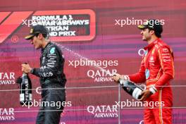 (L to R): Race winner George Russell (GBR) Mercedes AMG F1 celebrates on the podium with third placed Carlos Sainz Jr (ESP) Ferrari. 30.06.2024. Formula 1 World Championship, Rd 11, Austrian Grand Prix, Spielberg, Austria, Race Day.