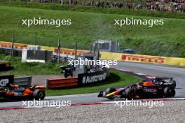 Max Verstappen (NLD) Red Bull Racing RB20 behind Lando Norris (GBR) McLaren MCL38, both with punctures after colliding. 30.06.2024. Formula 1 World Championship, Rd 11, Austrian Grand Prix, Spielberg, Austria, Race Day.