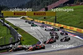 Sergio Perez (MEX) Red Bull Racing RB20 and Oscar Piastri (AUS) McLaren MCL38 at the start of the race. 30.06.2024. Formula 1 World Championship, Rd 11, Austrian Grand Prix, Spielberg, Austria, Race Day.