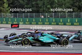Fernando Alonso (ESP) Aston Martin F1 Team AMR24 and Alexander Albon (THA) Williams Racing FW46. 30.06.2024. Formula 1 World Championship, Rd 11, Austrian Grand Prix, Spielberg, Austria, Race Day.
