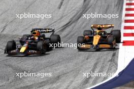 Max Verstappen (NLD) Red Bull Racing RB20 and Lando Norris (GBR) McLaren MCL38 battle for the lead of the race. 29.06.2024. Formula 1 World Championship, Rd 11, Austrian Grand Prix, Spielberg, Austria, Sprint and Qualifying Day.