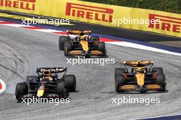 Max Verstappen (NLD) Red Bull Racing RB20 and Lando Norris (GBR) McLaren MCL38 battle for the lead of the race. 29.06.2024. Formula 1 World Championship, Rd 11, Austrian Grand Prix, Spielberg, Austria, Sprint and Qualifying Day.