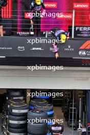 Esteban Ocon (FRA) Alpine F1 Team and Pierre Gasly (FRA) Alpine F1 Team deop their champagne to the team on the podium. 03.11.2024. Formula 1 World Championship, Rd 21, Brazilian Grand Prix, Sao Paulo, Brazil, Race Day.