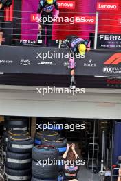 Esteban Ocon (FRA) Alpine F1 Team and Pierre Gasly (FRA) Alpine F1 Team deop their champagne to the team on the podium. 03.11.2024. Formula 1 World Championship, Rd 21, Brazilian Grand Prix, Sao Paulo, Brazil, Race Day.