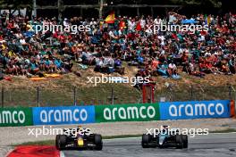 Max Verstappen (NLD) Red Bull Racing RB20 and George Russell (GBR) Mercedes AMG F1 W15 battle for position. 23.06.2024. Formula 1 World Championship, Rd 10, Spanish Grand Prix, Barcelona, Spain, Race Day.