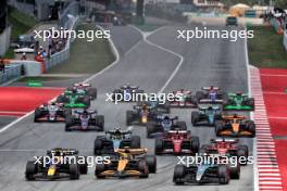 George Russell (GBR) Mercedes AMG F1 W15 leads Lando Norris (GBR) McLaren MCL38 and Max Verstappen (NLD) Red Bull Racing RB20 at the start of the race. 23.06.2024. Formula 1 World Championship, Rd 10, Spanish Grand Prix, Barcelona, Spain, Race Day.