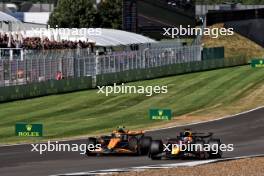Lando Norris (GBR) McLaren MCL38 and Max Verstappen (NLD) Red Bull Racing RB20 battle for position. 07.07.2024. Formula 1 World Championship, Rd 12, British Grand Prix, Silverstone, England, Race Day.
