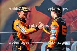 (L to R): Lando Norris (GBR) McLaren celebrates his second position with race winner and team mate Oscar Piastri (AUS) McLaren on the podium. 21.07.2024. Formula 1 World Championship, Rd 13, Hungarian Grand Prix, Budapest, Hungary, Race Day.