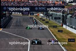 George Russell (GBR) Mercedes AMG F1 W15 and Yuki Tsunoda (JPN) RB VCARB 01 battle for position. 07.04.2024. Formula 1 World Championship, Rd 4, Japanese Grand Prix, Suzuka, Japan, Race Day.