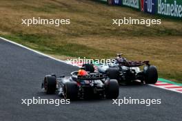 Sergio Perez (MEX) Red Bull Racing RB20 and George Russell (GBR) Mercedes AMG F1 W15 battle for position. 07.04.2024. Formula 1 World Championship, Rd 4, Japanese Grand Prix, Suzuka, Japan, Race Day.