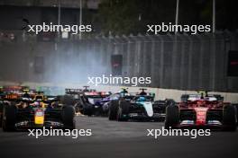 Max Verstappen (NLD) Red Bull Racing RB20 and Carlos Sainz Jr (ESP) Ferrari SF-24 lead at the start of the race as Yuki Tsunoda (JPN) RB VCARB 01 crashes. 27.10.2024. Formula 1 World Championship, Rd 20, Mexican Grand Prix, Mexico City, Mexico, Race Day.